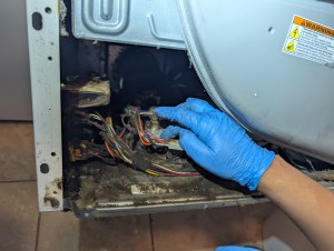 Close-up of new gas valve coil being installed in dryer burner assembly